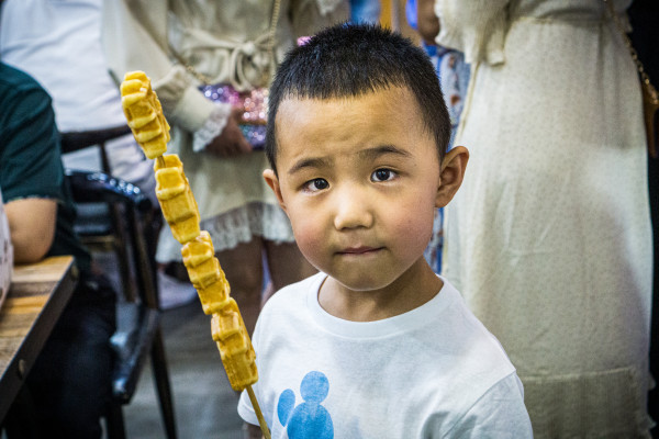 Chinese kid with pankake skewer